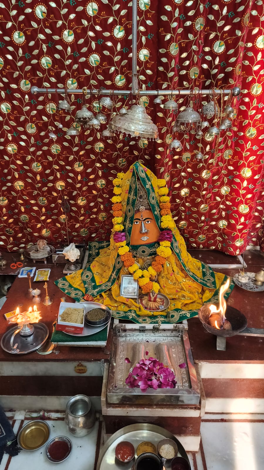 Devotional offerings and lamps at the shrine of Sushmad Mataji